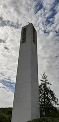 Der Kirchturm der Christkönigkirche zeigt wie ein Finger zum Himmel. Der Turm steht etwas abseits zur Kirche.